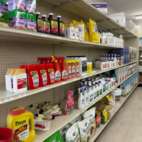 Store aisle with shelves displaying various garden products, including insecticides, fertilizers, and weed killers. The neatly arranged items suggest a well-organized retail space.